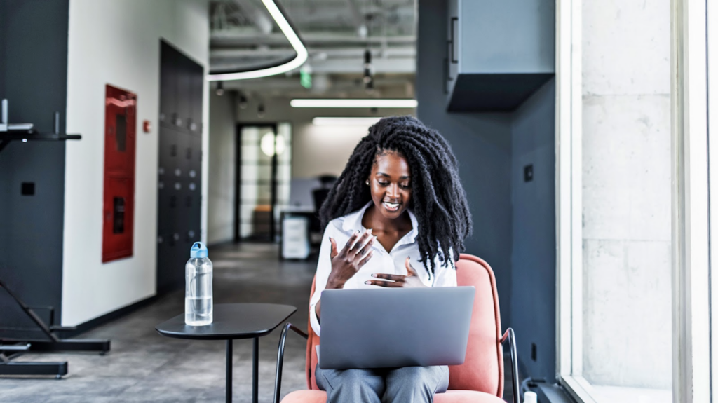 A women sitting in a chair with her laptop on her lap